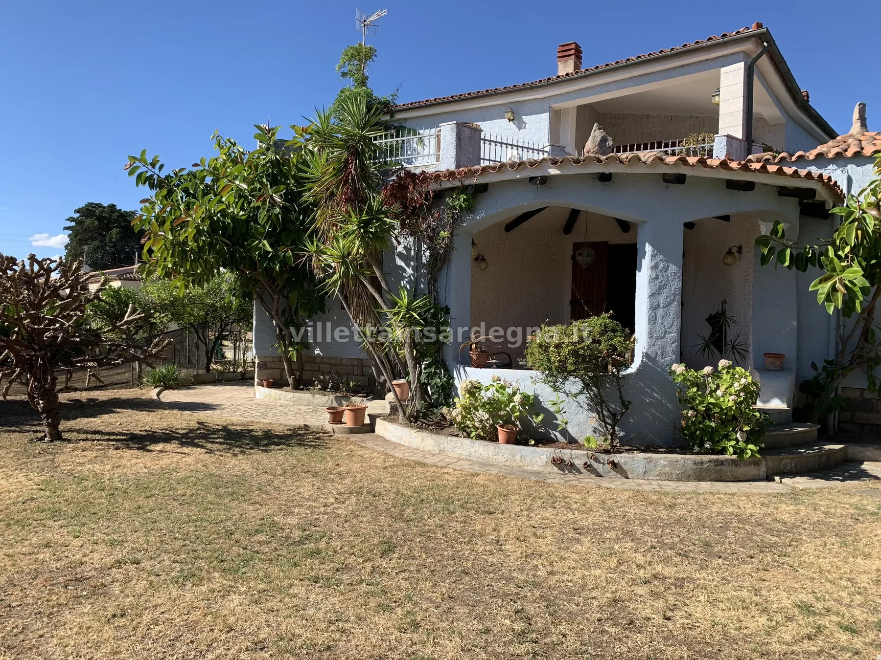 Villa Lauretta vista dal giardino, con veranda e vegetazione mediterranea